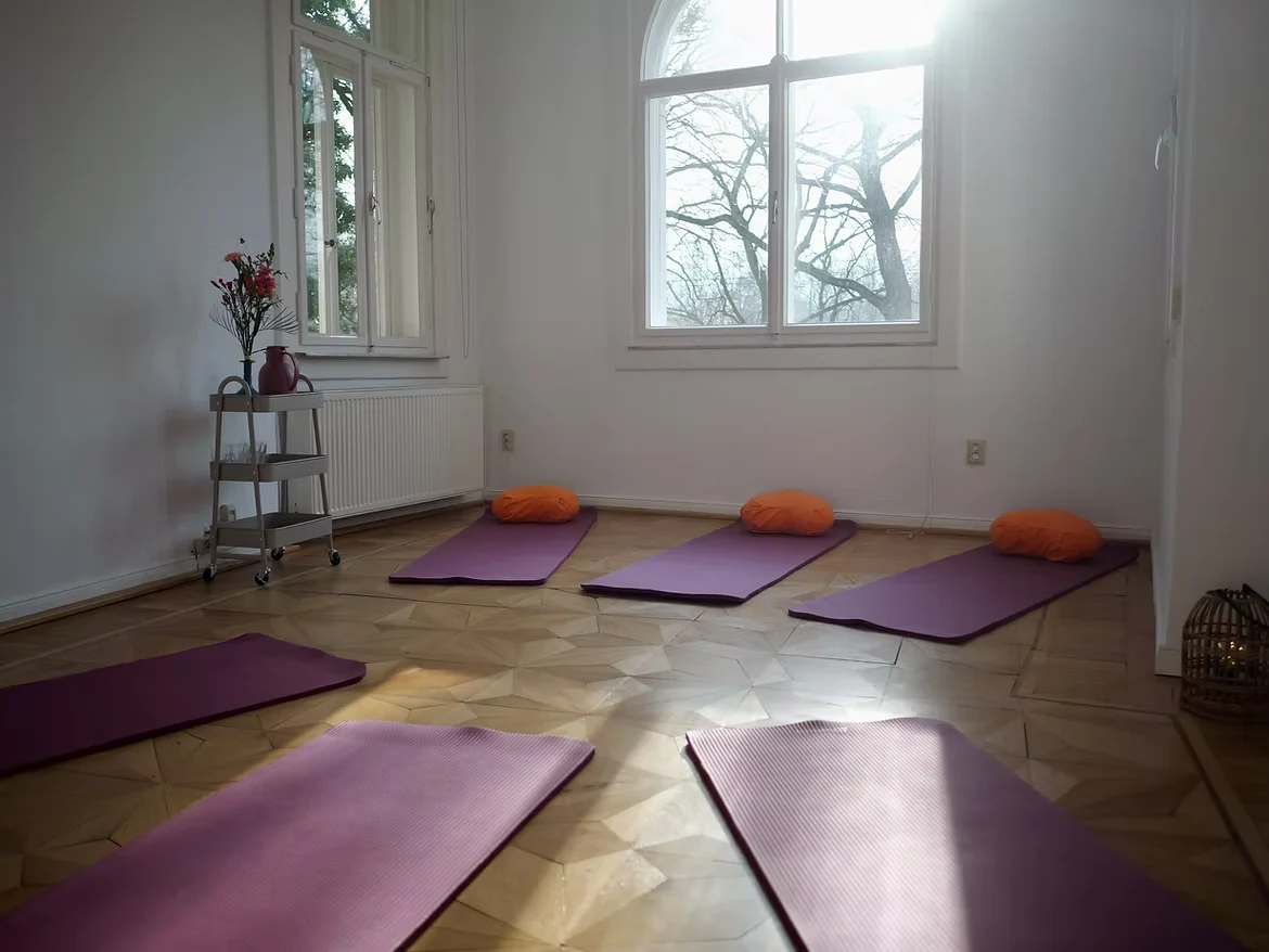 Lichtdurchfluteter Kursraum des Hebammenkollektivs mit Yogamatten und Sitzkissen